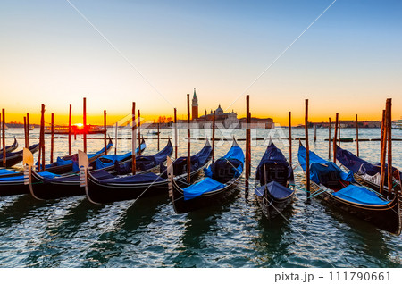 Gondolas moored by Saint Mark square against San Giorgio di Maggiore church in Venice, Italy. 111790661