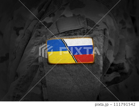 Ukraine vs Russia. Ukrainian Russian conflict. Flag of Ukraine and Russia at military uniform (collage) 111791542
