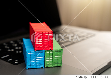 Ship container on laptop keyboard. Trade, economics and transport industry. Production of containers. Import or export. Registration of deliveries and transportation with sea transport operators. 111792044