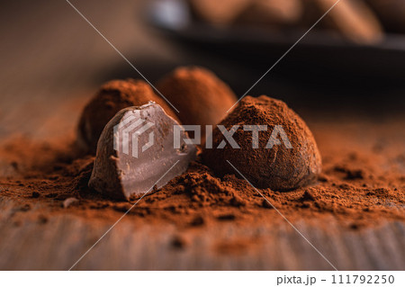 Chocolate truffles covered with cocoa powder on wooden table. 111792250