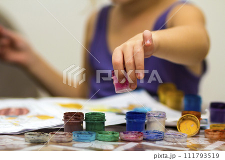 Cute little girl painting with brush and colourful paints Cute little girl painting with brush and colourful paints 111793519