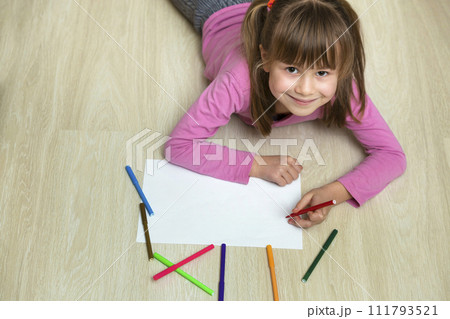 Cute child girl drawing with colorful pencils crayons on white paper. Art education, creativity concept. 111793521