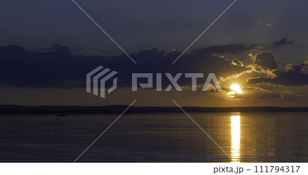 Sunset over lake. clouds. Water. San in the sky. 111794317
