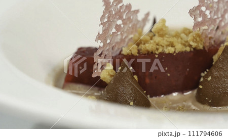 Salad of baked beets, arugula, cheese and nuts. Fresh salad with beets and oranges, food. Vegetarian lean lettuce from beet, onion, walnuts, serving on a white plate close up 111794606