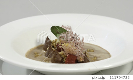 Beetroot salad. Salad with roasted beetroot, spinach, soft goat cheese and seeds in light plate over grey concrete textured background, oil in saucer. Top view 111794723