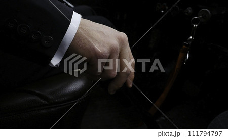 Businessman driving to work, hand shifting the gear stick. Businessman shifts the transmission in the rare machine. Businessman driving car hand shifting the gear stick. Retro style Businessman driving to work, hand shifting the gear stick. Businessman shifts the transmission in the rare machine. Businessman driving car hand shifting the gear stick. Retro style 111794797
