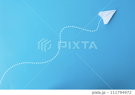 Top view of paper airplane on blue background Top view of paper airplane on blue background 111794972
