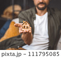 Man holding a small wooden house in his hand. 111795085