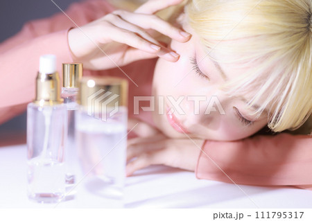 化粧品を眺める若い女性 111795317