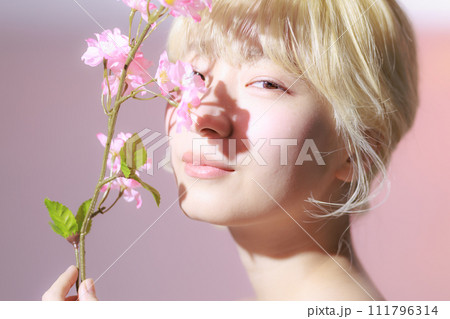 花を持つ韓国メイクをした若い女性 111796314