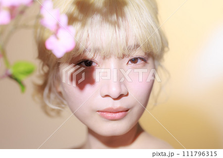 花を持つ韓国メイクをした若い女性 111796315