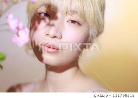 花を持つ韓国メイクをした若い女性 111796318