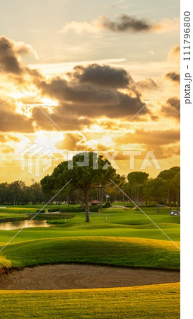 Panorama Golf course with a sand bunker in the center. Dramatic clouds in the sky during sunset Belek Turkey 111796800