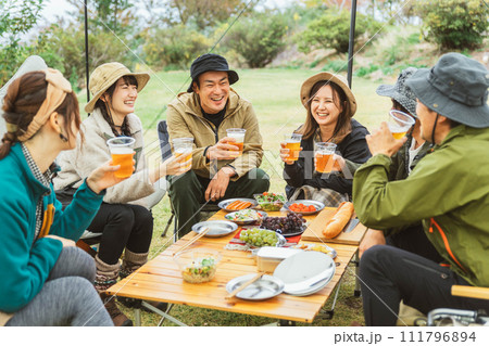 キャンプ・デイキャンプ・グループキャンプでビールを飲みながら談笑する男女キャンパー キャンプ・デイキャンプ・グループキャンプでビールを飲みながら談笑する男女キャンパー 111796894
