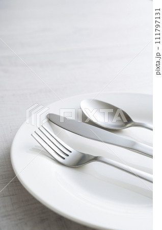 シンプルな白い皿とフォークとナイフとスプーン 111797131