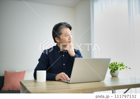 リビングでテレワークをするミドル男性 リビングでテレワークをするミドル男性 111797132