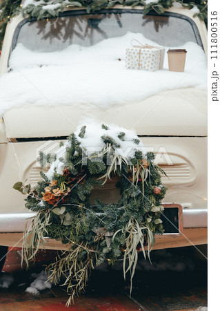 Vintage car decorated for the holidays Christmas, car front decorated with wreath Vintage car decorated for the holidays Christmas, car front decorated with wreath 111800516