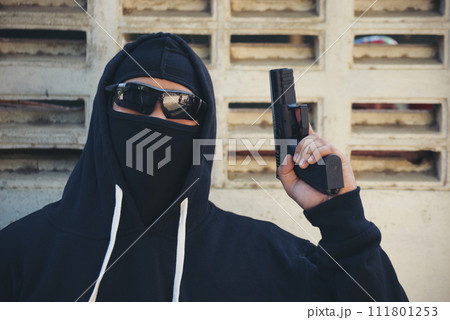 Terrorist war criminal men holding gun weapon in hand mafia attack make a crime thief in black dress medium shot. Bad anonymous soldier army. Illegal bandit murderer criminal terrorist war concept Terrorist war criminal men holding gun weapon in hand mafia attack make a crime thief in black dress medium shot. Bad anonymous soldier army. Illegal bandit murderer criminal terrorist war concept 111801253
