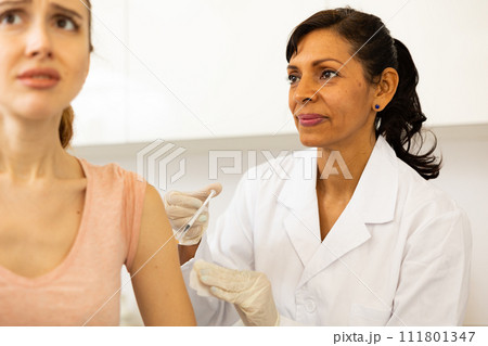 Doctor injecting shot of vaccine to woman Doctor injecting shot of vaccine to woman 111801347