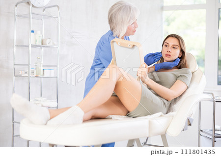 Cosmetologist with gloves preparing patient to skin care procedure in spa salon. 111801435