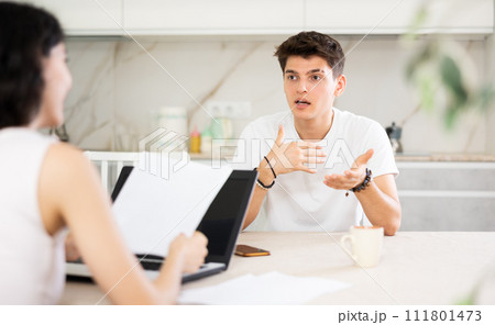 Girl manager tells guy client about specifics of design of microloan, about benefits and advantages. 111801473