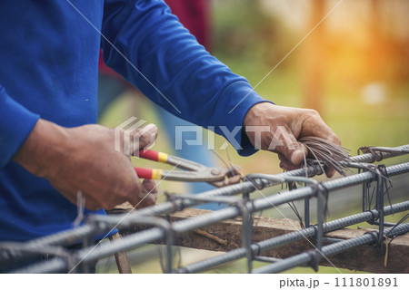 Construction Worker hands using pincer pliers iron wire. Outdoor Worker using wire bending pliers, construction work. Men hands bending cutting steel wire fences bar reinforcement of concrete work 111801891