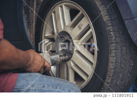 Close up Mechanic man hands repairing car auto repair shop uses jack change tyre. Man hands fixing Shock absorber machinery vehicle mechanical service. Vehicle Car overhaul maintenance engineer Close up Mechanic man hands repairing car auto repair shop uses jack change tyre. Man hands fixing Shock absorber machinery vehicle mechanical service. Vehicle Car overhaul maintenance engineer 111801911