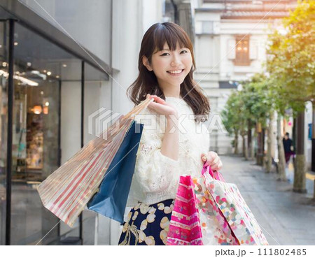 楽しくショッピングをして買い物袋を持つ女性 111802485
