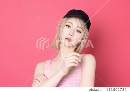 ピンク背景で撮影をした若い女性のポップなポートレート 111802723