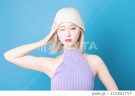 青背景で撮影をした若い女性のポップなメイクアップイメージ 111802757