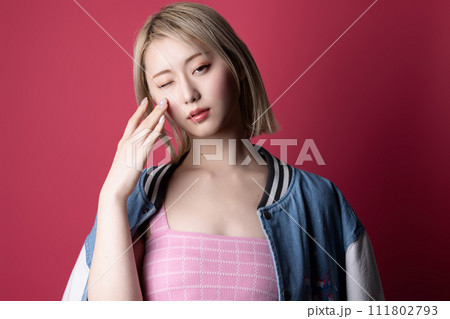 ピンク背景で撮影をした若い女性のカジュアルなポートレート 111802793