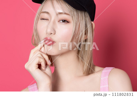 ピンク背景で撮影をした若い女性のポップなポートレート 111802831