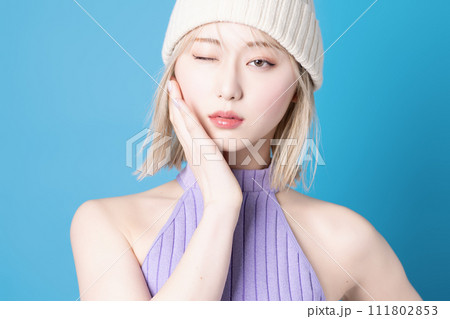 青背景で撮影をした若い女性のポップなメイクアップイメージ 111802853