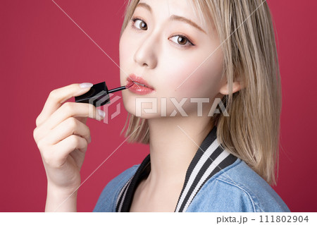 ピンク背景で撮影をした若い女性のポップなポートレート 111802904
