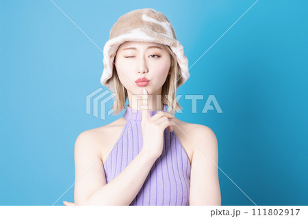 青背景で撮影をした若い女性のポップなメイクアップイメージ 111802917