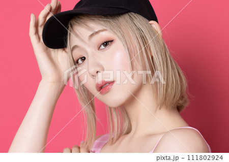 ピンク背景で撮影をした若い女性のポップなポートレート 111802924