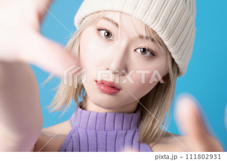 青背景で撮影をした若い女性のポップなメイクアップイメージ 111802931