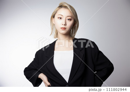 黒いジャケットを着た若いハイトーンの女性のクールなポートレート 111802944
