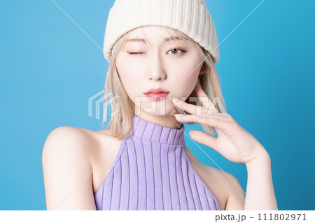 青背景で撮影をした若い女性のポップなメイクアップイメージ 111802971