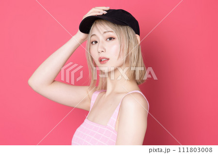 ピンク背景で撮影をした若い女性のポップなポートレート 111803008
