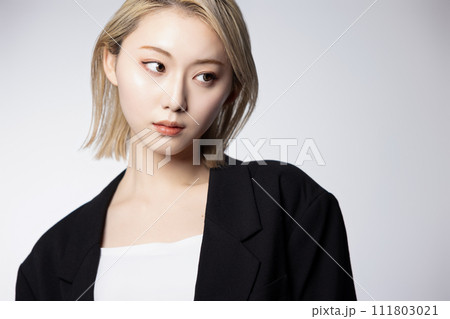 黒いジャケットを着た若いハイトーンの女性のクールなポートレート 111803021