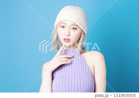 青背景で撮影をした若い女性のポップなメイクアップイメージ 111803058