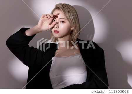 黒いジャケットを着た若い女性の光と影背景のポートレート 黒いジャケットを着た若い女性の光と影背景のポートレート 111803068