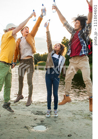 Jubilant Friends Celebrating with a Toast by the Lake Jubilant Friends Celebrating with a Toast by the Lake 111804601