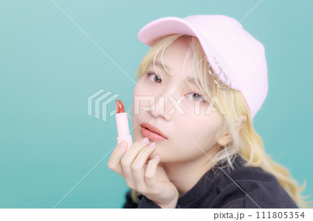 韓国メイクをしてグロスを持った若い女性 韓国メイクをしてグロスを持った若い女性 111805354