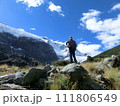 ニュージーランド、ロブロイ氷河のある山頂を眺める登山者の男性の後ろ姿 111806549