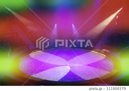 The circus arena in light rays and multi-colored lights is photographed from above. The circus arena in light rays and multi-colored lights is photographed from above. 111808379