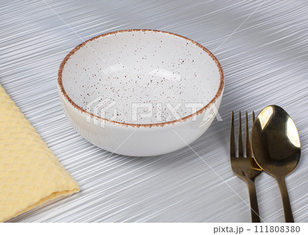 Ceramic clay plate with spoon and fork on gray background 111808380