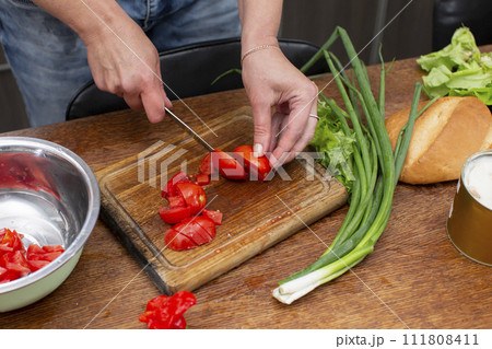 Chop the green onions and tomatoes and place them in a bowl. Prepare the salad. Chop the green onions and tomatoes and place them in a bowl. Prepare the salad. 111808411