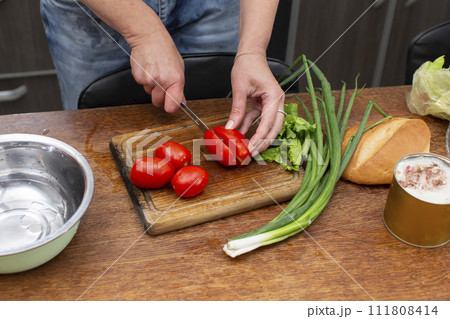 Chop the green onions and tomatoes and place them in a bowl. Prepare the salad. Chop the green onions and tomatoes and place them in a bowl. Prepare the salad. 111808414